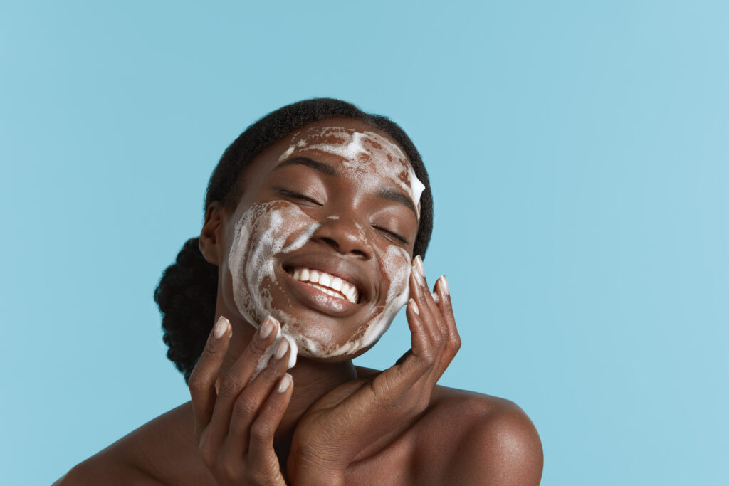 mulher negra aplicando cleansing oil