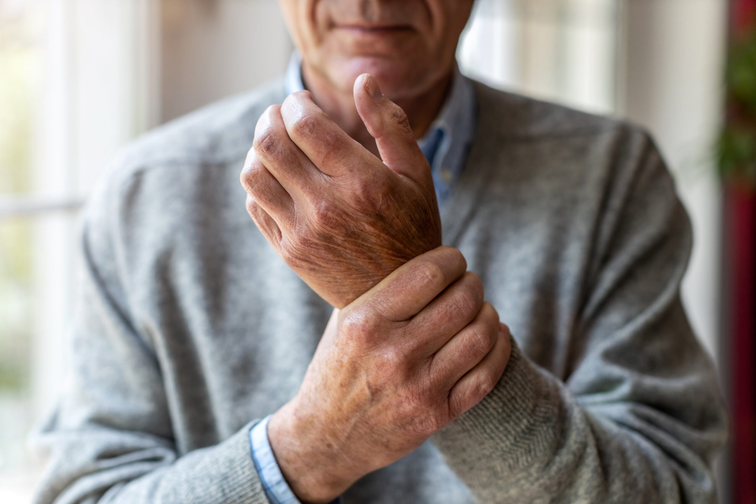 idoso com dores nos punhos, sinal de osteoporose