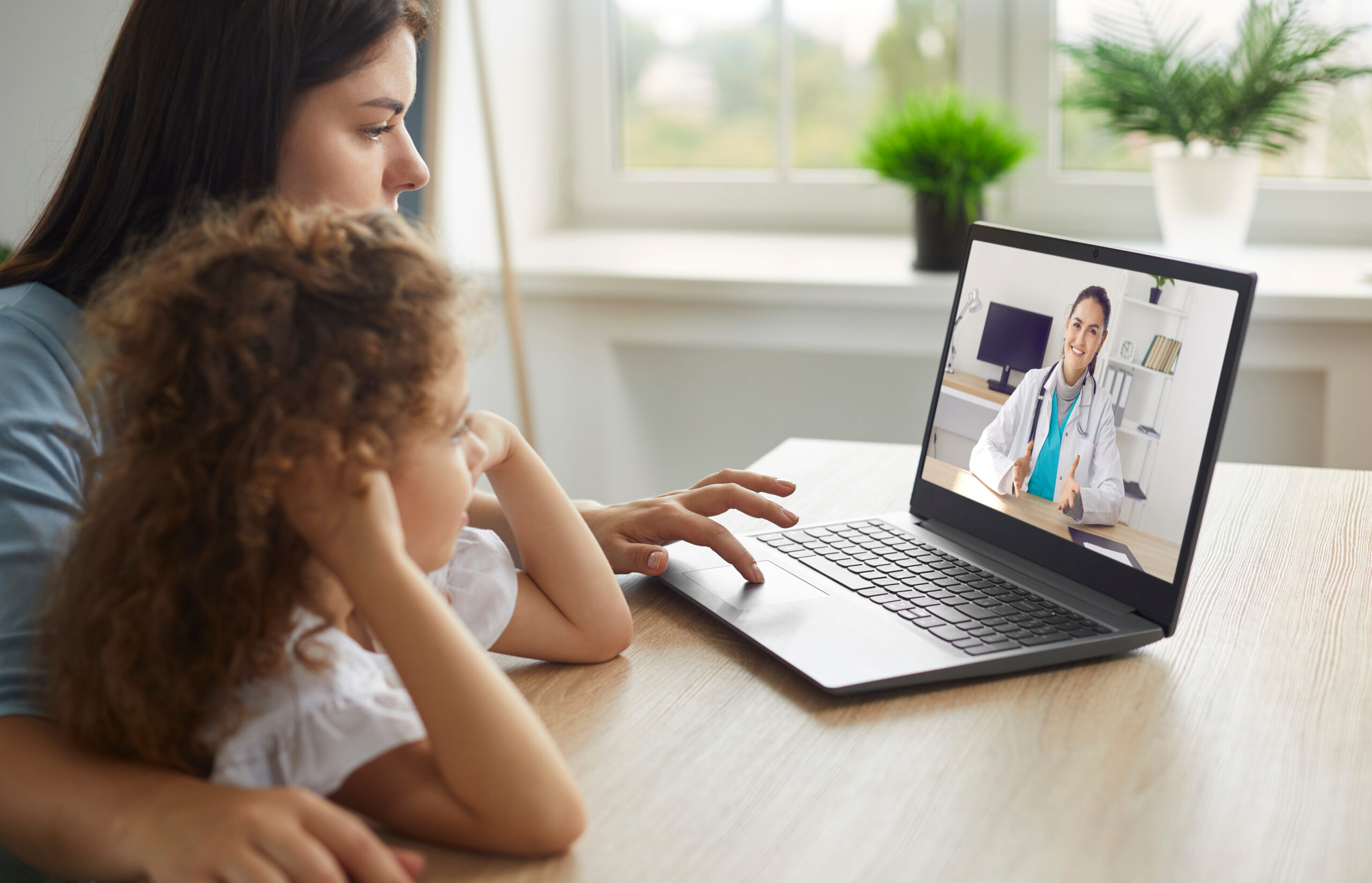 Mãe e filha realizando atendimento médico por meio da telemedicina