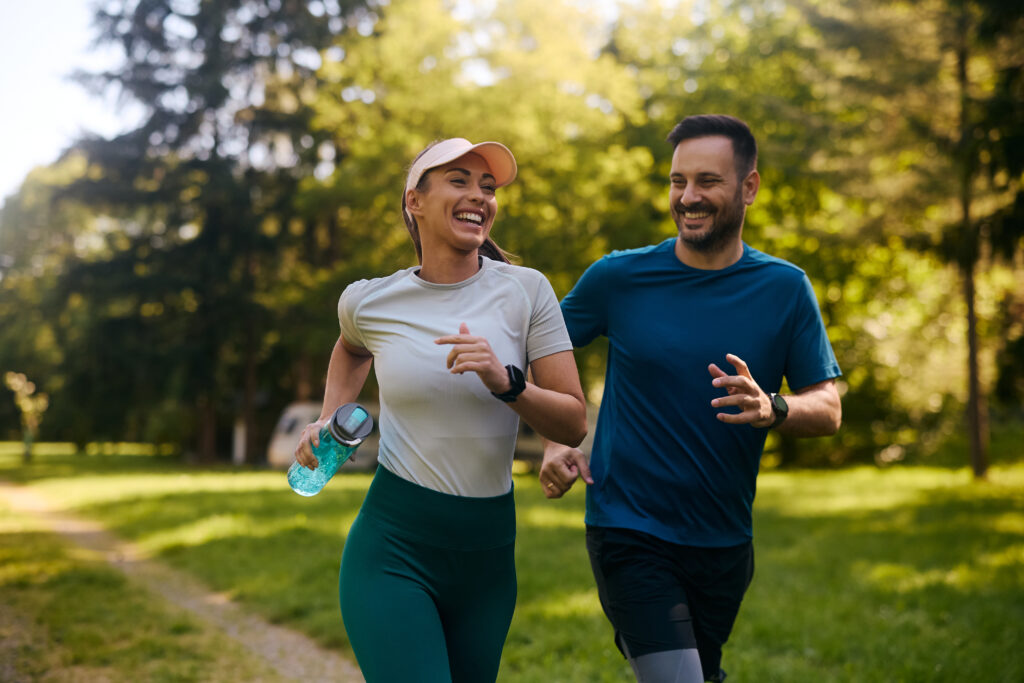 casal de homem e mulher felizes praticando corrida ao ar livre
