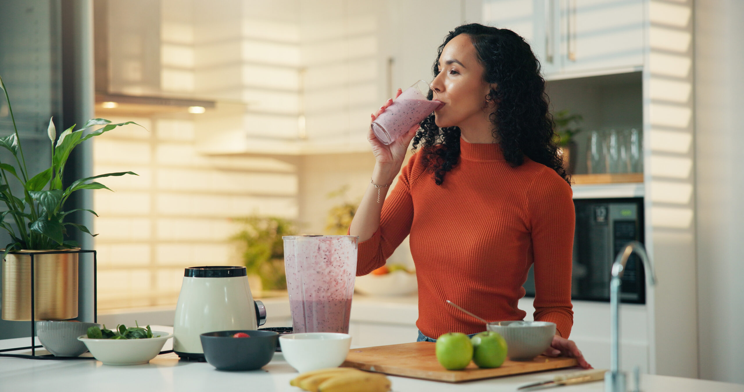 mulher tomando vitamina na cozinha de casa