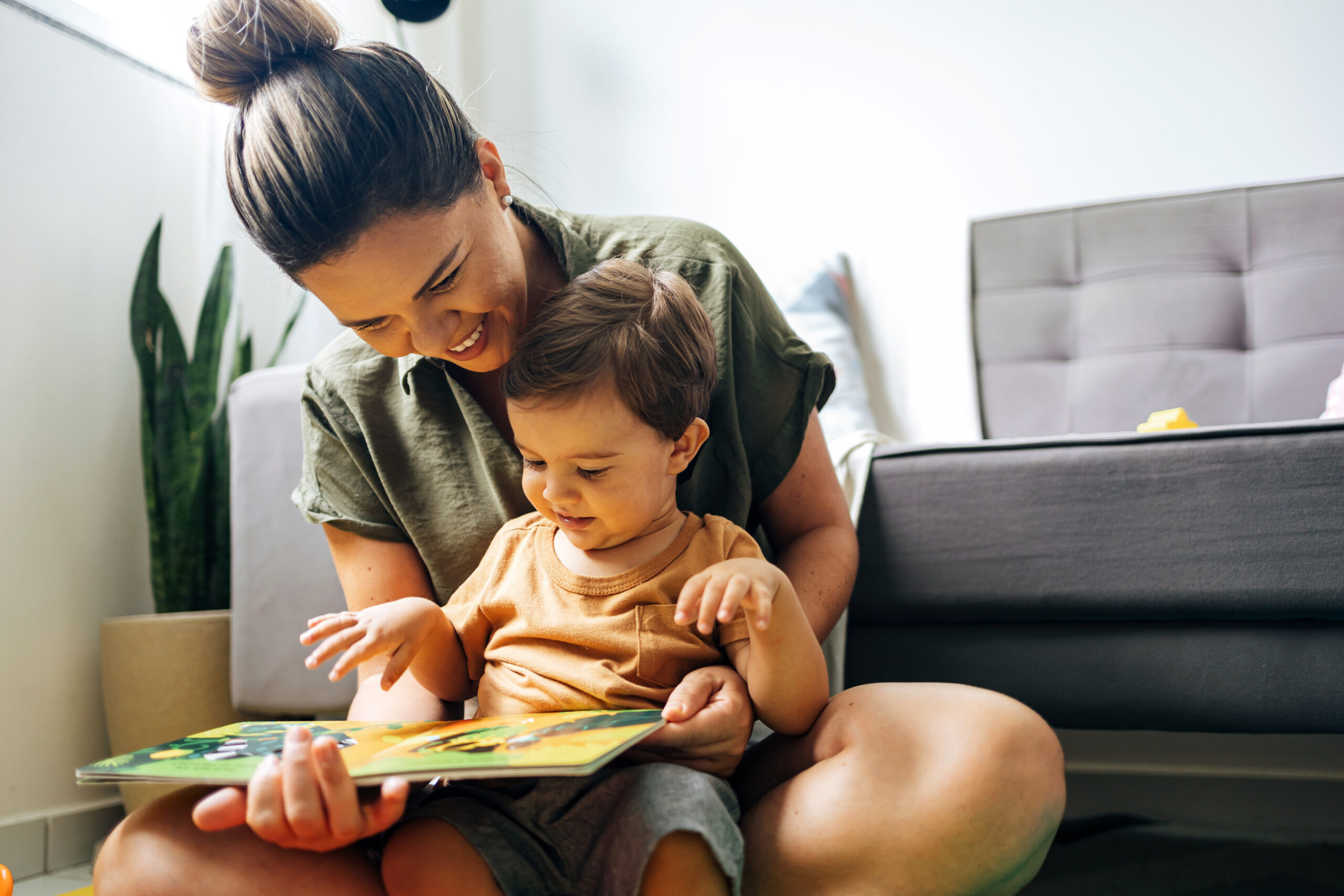 mãe e filho felizes lendo livro juntos
