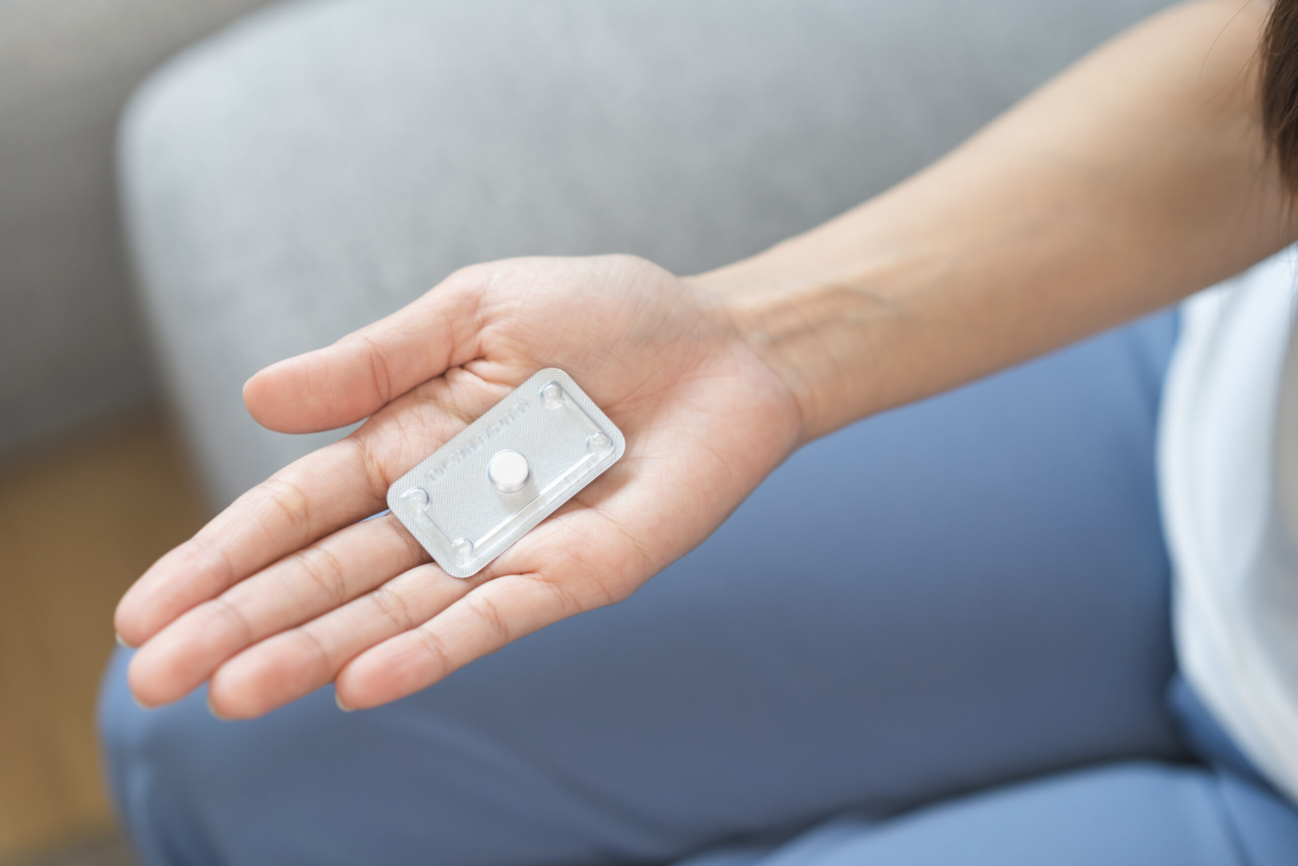 mulher segurando pílula anticoncepcional