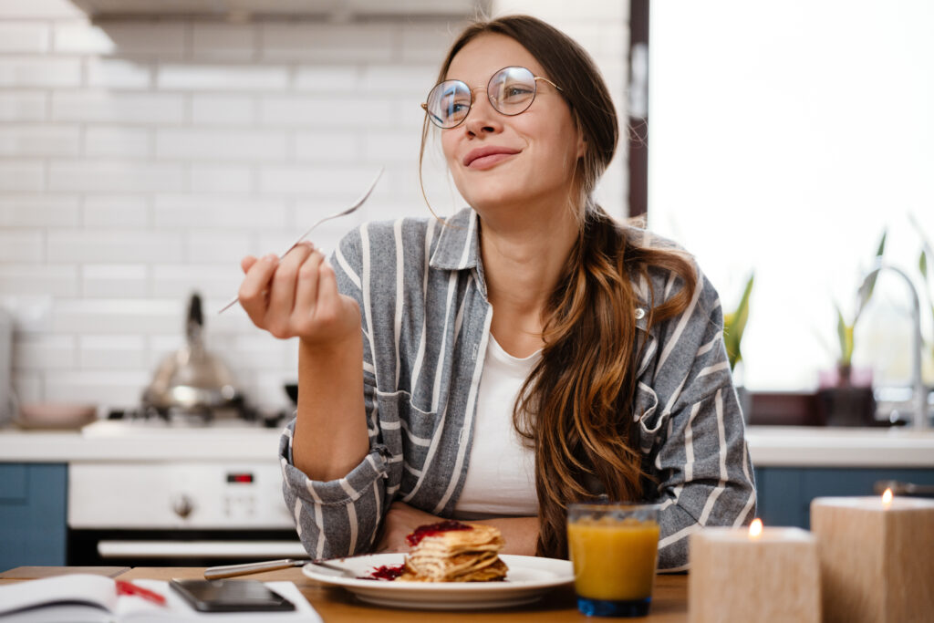 mulher tomando café da manhã feliz em casa