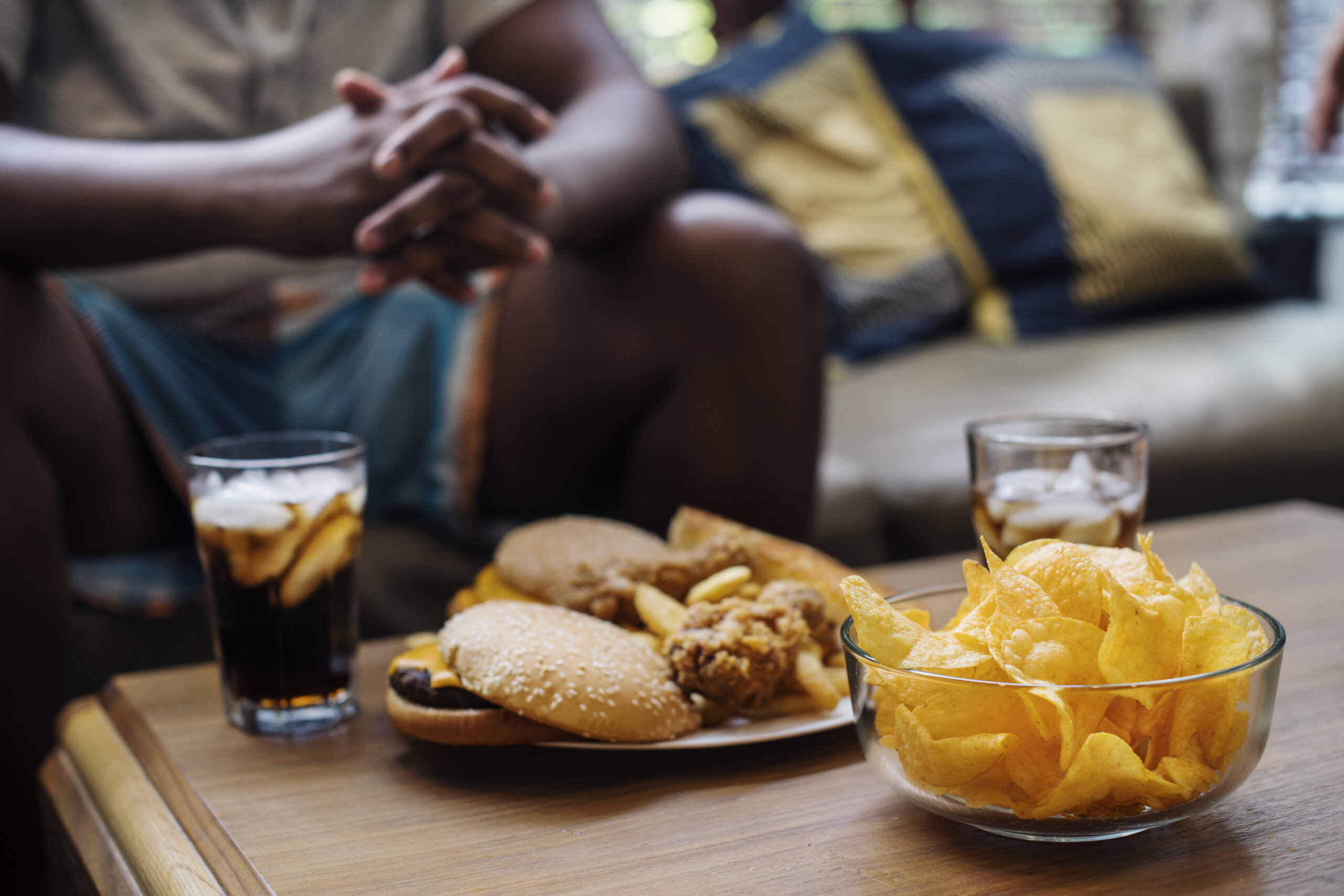 fast food na mesa de sofá, hábito comum na alimentação que impacta o peso
