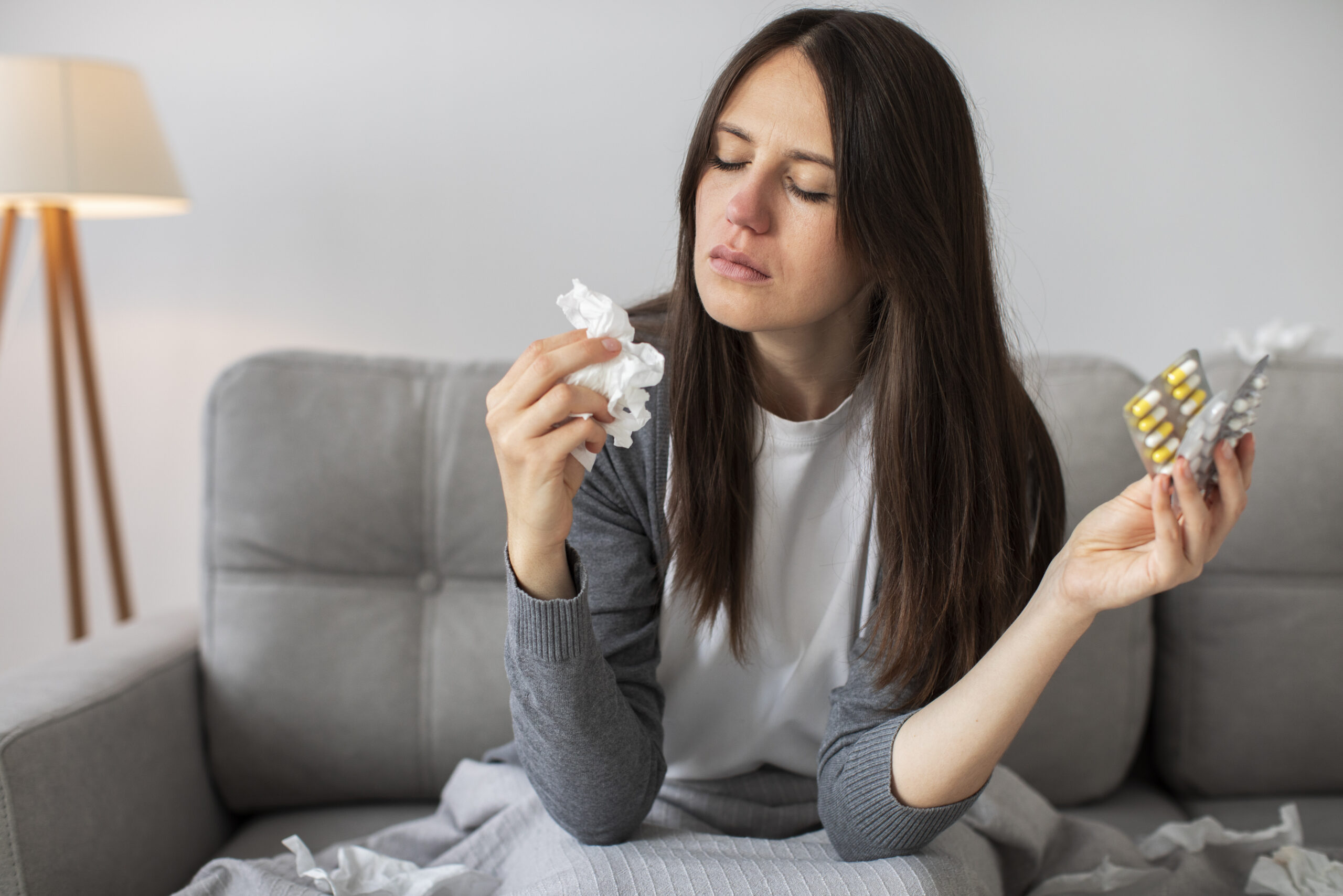 mulher com alergia tomando antialérgico