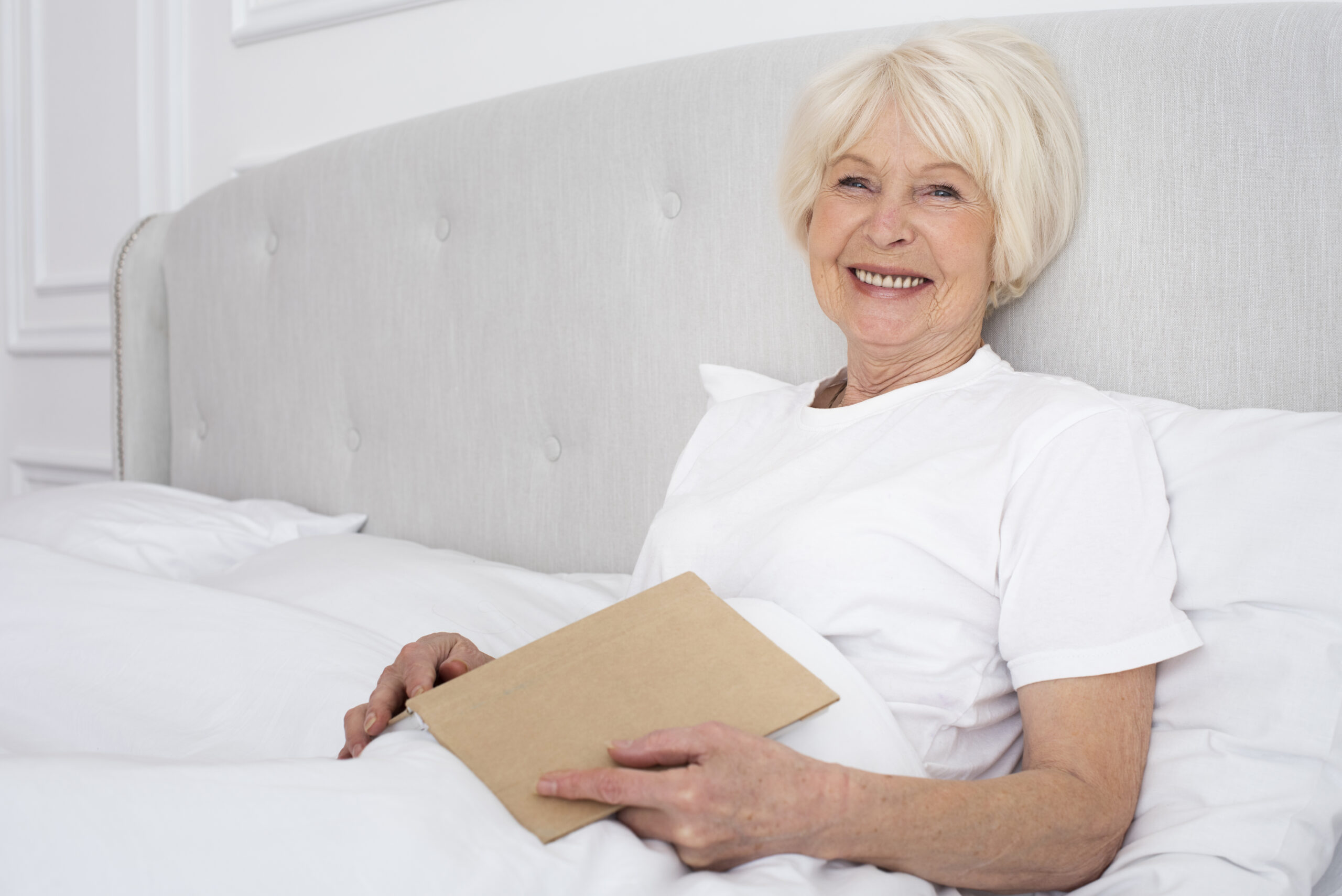 mulher idosa confortável na cama pois está utilizando a melhor opção de fralda geriátrica