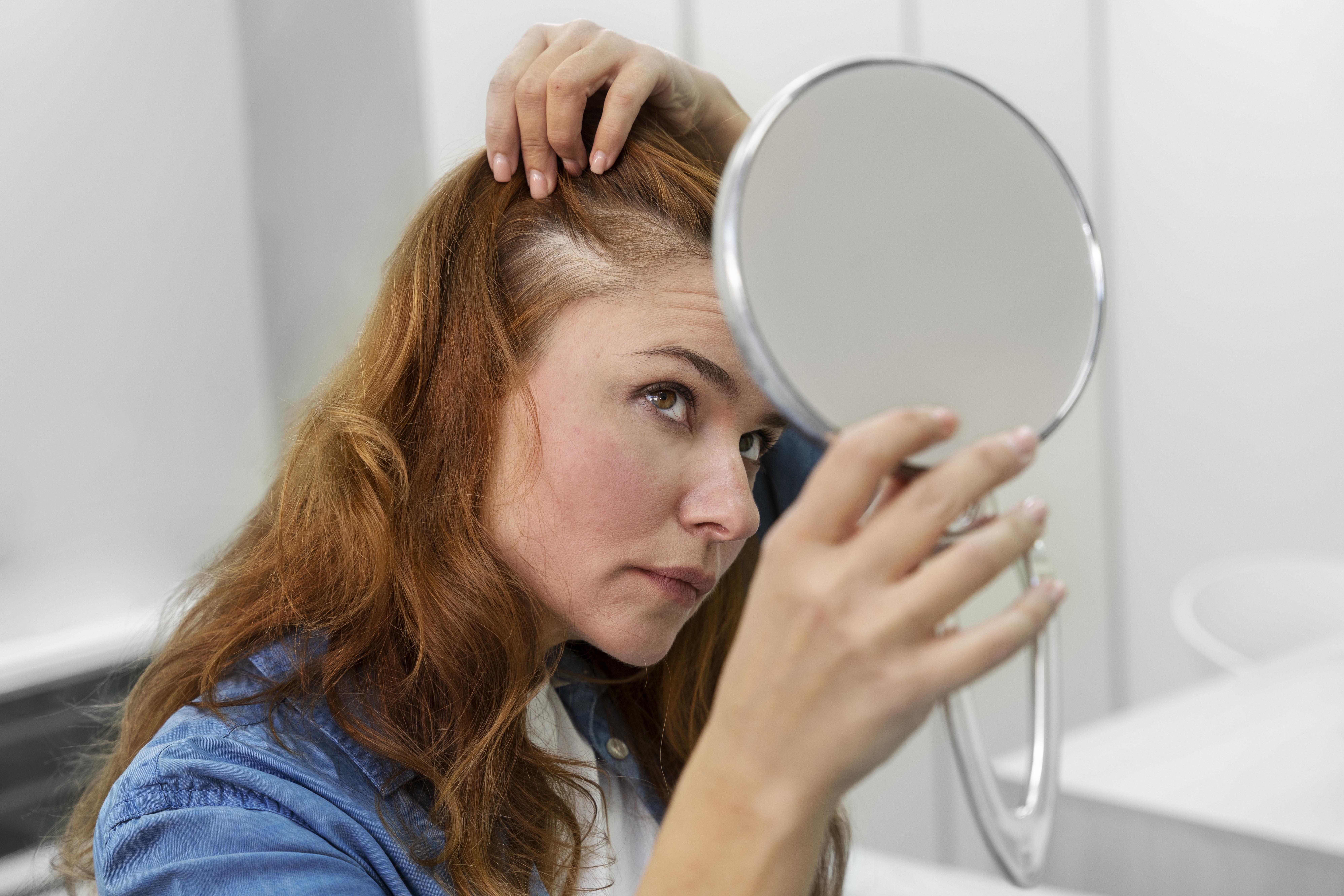 mulher conferindo o cabelo após iniciar o uso do shampoo antiqueda