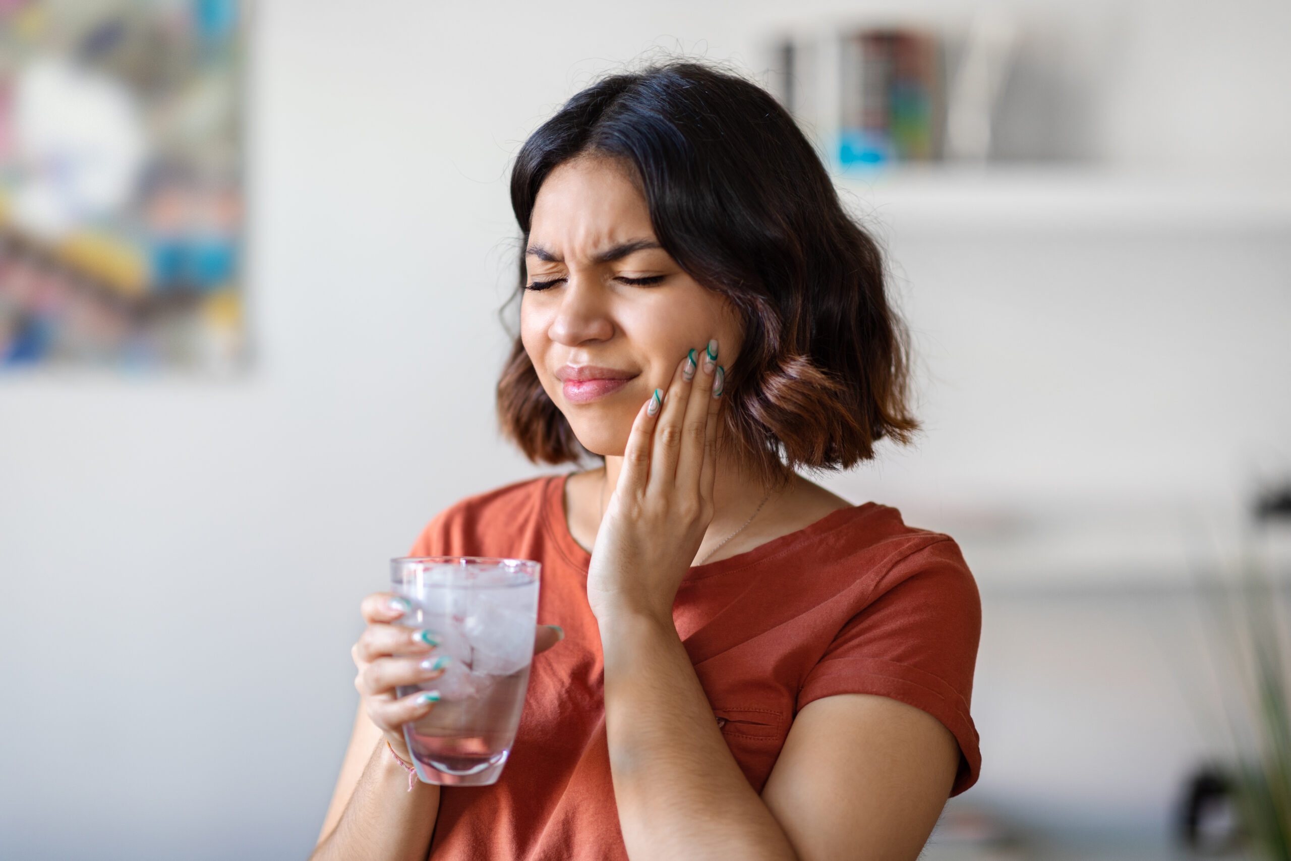 mulher sofrendo de sensibilidade nos dentes